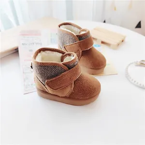 Close-up view of brown children's winter snow boots featuring warm fleece lining and Velcro strap
