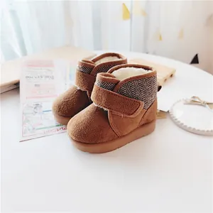 Close-up of warm brown toddler snow boots with chevron pattern and cozy fleece lining.