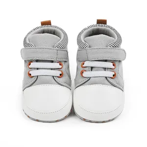 Graue Baby Lauflernschuhe aus Segeltuch mit weißer Zehenkappe und Streifen