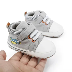 Graue Baby-Lernlaufschuhe aus Canvas mit weißer Gummikappe und Flugzeug-Aufnäher