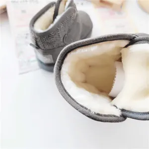 Detailed view showing thick white faux fur lining inside grey kids winter snow boots