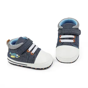 Nahaufnahme von Baby-Lauflernschuhen aus blauem Denim mit niedlicher Flugzeug-Stickerei.