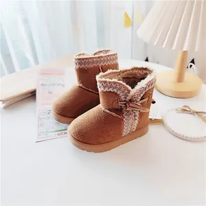 Detailed view of warm brown children's snow boots featuring cozy fur lining and ethnic trim