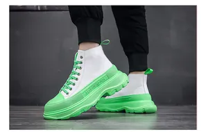 Vista dettagliata di stivaletti bianchi da uomo con zeppa verde neon molto vivace.
