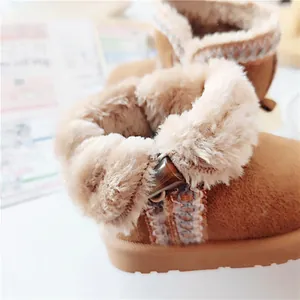 Close-up showing the soft plush faux fur lining and suede texture of kids snow boots