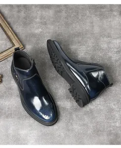 Détail des bottines Chelsea Brogue bleu marine brillant avec perforations décoratives.