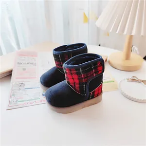 Cozy red and black plaid children's winter snow boots in a lifestyle setting