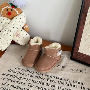 Détail de bottes de neige marron pour bébé avec doublure en polaire blanche et bride