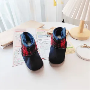 Detailed view of children's warm winter snow boots with a red plaid collar