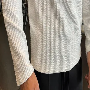 Close-up of white textured vertical knit fabric on men's long-sleeve sweater