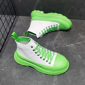 Vista laterale di stivali bianchi alti con spessa suola platform verde brillante.
