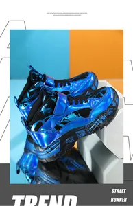 Detailed view of blue metallic children's snow boots with graffiti patterns on thick soles.