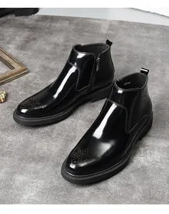 Gros plan sur le cuir noir brillant et le motif brogue de ces bottines Chelsea homme