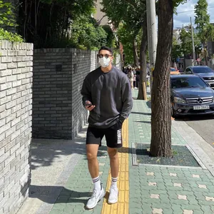 Stylish outdoor street view of a man wearing a grey textured knit long-sleeved sweater