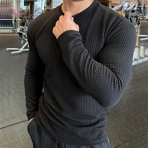 Close-up detail of black men's long sleeve sweater featuring unique ribbed knit texture.
