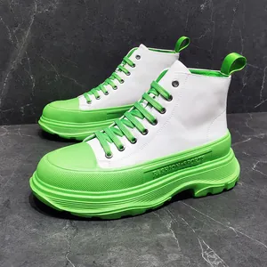 Eleganti stivaletti bianchi da uomo con suole platform e lacci verde neon accesi.