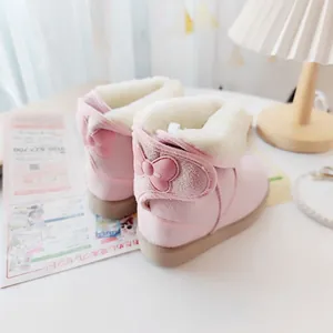 Close-up of pink children's snow boots with bow detail and warm fur lining