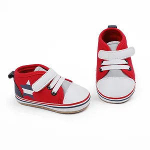 Detalle de zapatos rojos de bebé para primeros pasos con cierre de velcro y estrella.