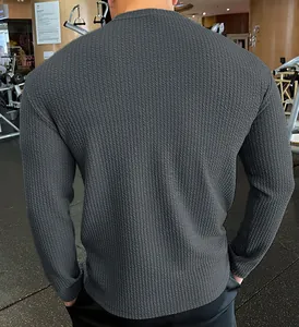 Detailed back view showing the texture of men's dark gray cable-knit long-sleeved sweater.