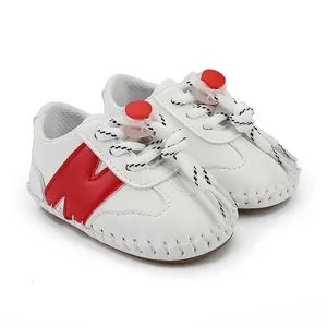 Vista detallada de zapatos blancos para bebé con logo N rojo y suela suave flexible