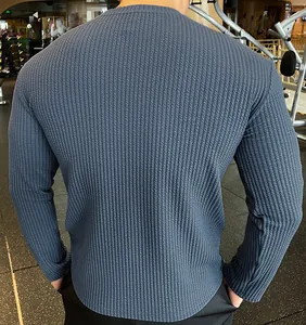 Back view of a men's stylish blue vertical stripe textured knitted sweater in gym