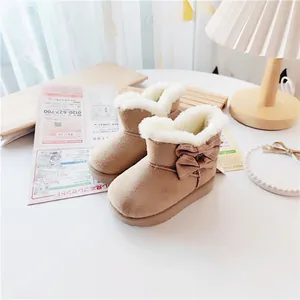 Cozy tan children's winter snow boots with warm faux fur lining and decorative side bow detail