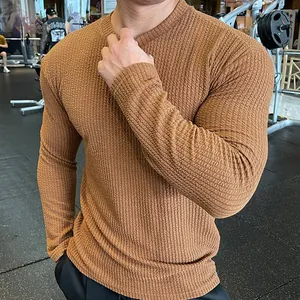Detailed close-up of textured waffle knit fabric on a men's slim-fit long-sleeve sweater