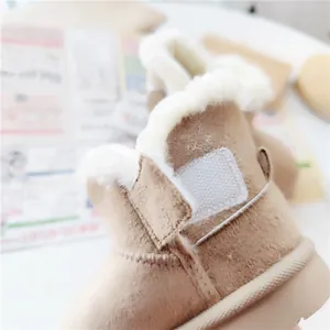 Detail view of warm children's snow boots with white faux fur lining and velcro strap.
