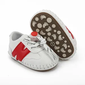 Primer plano de zapatos de bebé con suela de goma antideslizante y detalles rojos