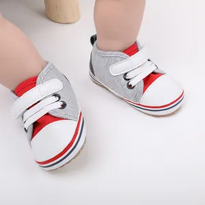 Detalle de los zapatos de suela blanda grises y rojos para bebés de 0 a 1 año