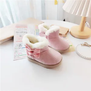 Detail of pink children's winter snow boots with soft fur lining and cute bow accent