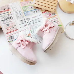 Detailed view of pink toddler snow boots with cute bow decoration and white fleece lining
