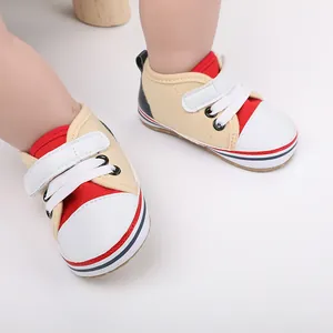 Vista detallada de zapatos de suela blanda para bebés en lona color beige y rojo