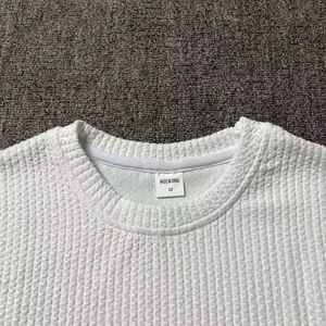 Close-up of neckline and size M tag on a white textured knit sweater
