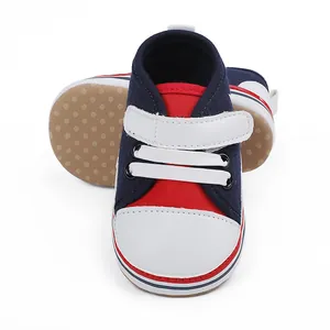 Detalle de zapatos de gateo para bebé en rojo y azul marino con suela blanda, 0-1 año.