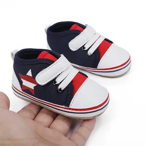 Detalle de zapatillas de bebé azul marino con estrella sostenidas para ver el tamaño.
