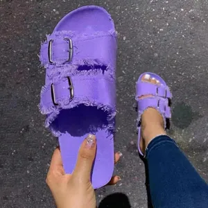Detailed view of purple canvas slide sandals featuring frayed edges and double metal buckles.