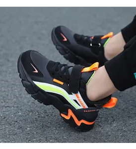 Detailed view of kids outdoor sports sneakers in black with vibrant orange and lime accents