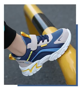 Side detail view of durable kids' navy and beige athletic running shoes with yellow accents