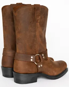 Close-up detail of distressed brown leather harness boots with metal rings