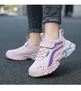 Dettaglio di scarpe da corsa rosa per bambini con suole antiscivolo su una strada asfaltata.