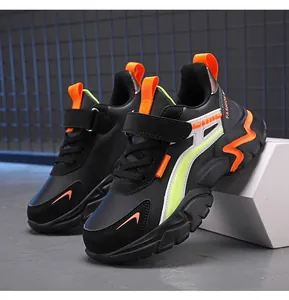 Side view of black children's sneakers with vibrant orange and neon green accents