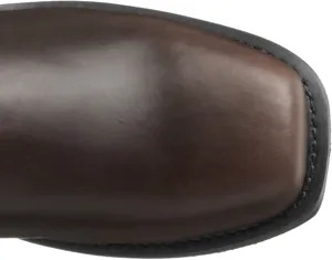 Close-up detail of a dark brown leather boot with a square toe and black stitched sole.