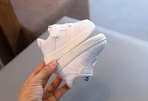 Close-up view of white toddler walking shoes with soft soles and velcro straps.