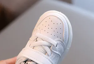 Close-up detail of white toddler walking shoes with breathable leather toe cap