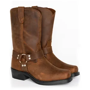 Classic brown leather harness boots with metal buckle detailing on white background.