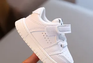 Close-up detail of white toddler walking shoes with soft non-slip sole and Velcro strap