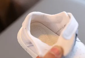 Close-up detail of soft breathable mesh interior lining of white toddler walking shoes