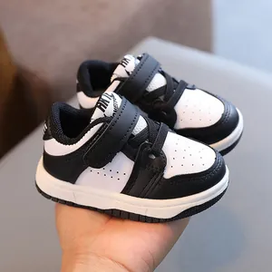 Classic black and white toddler sneakers featuring adjustable Velcro straps for daily wear