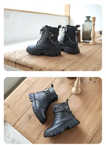 Detailansicht schwarzer Kinder-Stiefeletten mit Metallketten und Schnallendetails.
